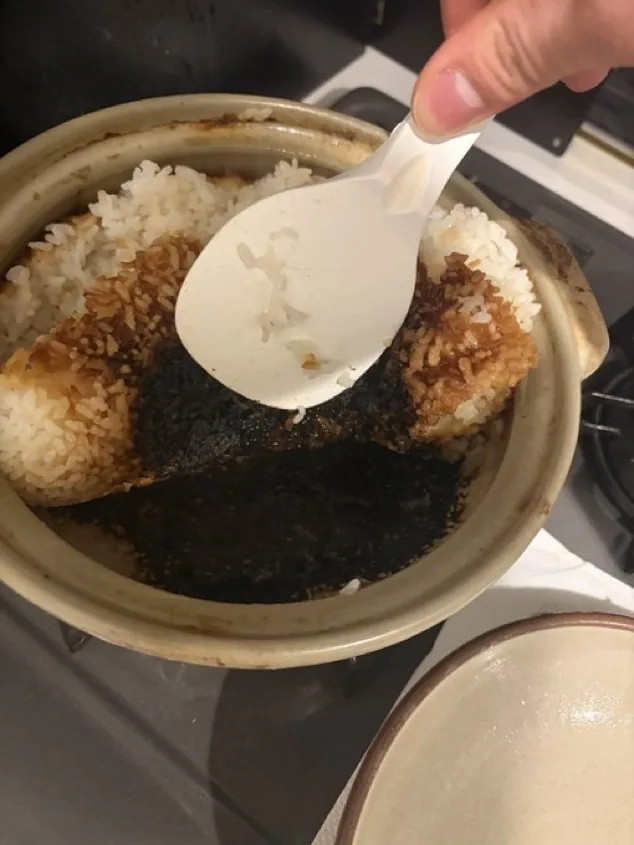 Blackened burnt rice stuck to the bottom of a donabe after excessive heat