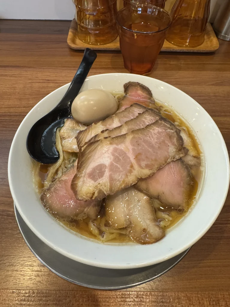 Bowl of ramen covered with thick slices of chashu and topped with a seasoned egg