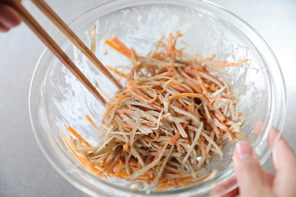 Japanese Gobo and Carrot Salad Cooked gobo and carrot being mixed into a creamy Japanese salad