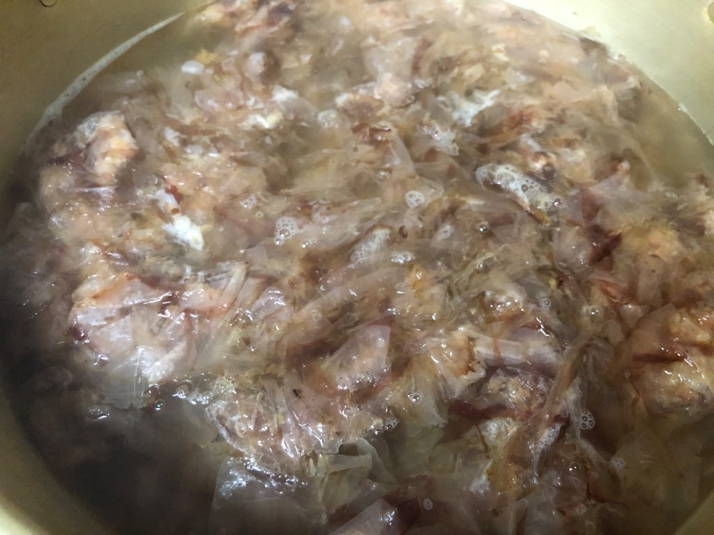 Katsuobushi flakes steeping in hot water during dashi preparation