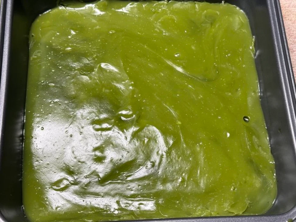 Matcha Warabi Mochi in a Tray Fresh green matcha warabi mochi cooling in a black tray before portioning
