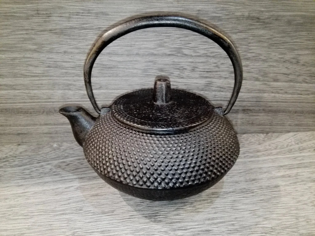 Black cast-iron Japanese teapot with an arched metal handle