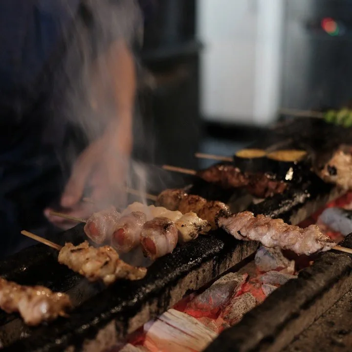 Yakitori skewers grilling over charcoal at a Japanese restaurant