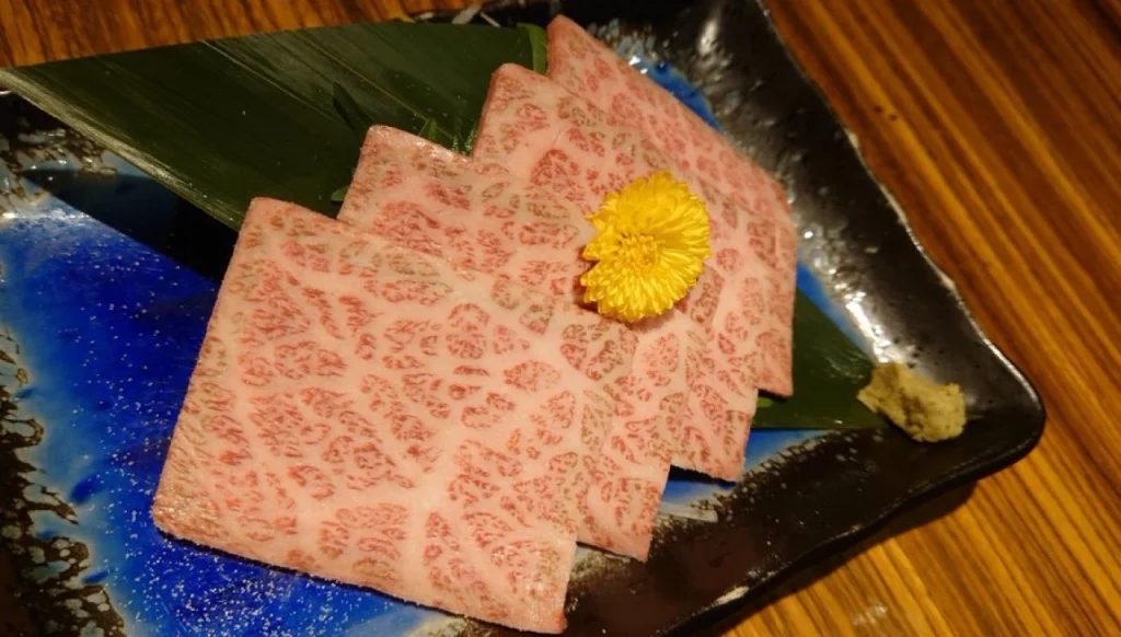 Thinly Sliced A5 Wagyu Before Searing Thin slices of highly marbled A5 Wagyu arranged on a Japanese ceramic plate before searing