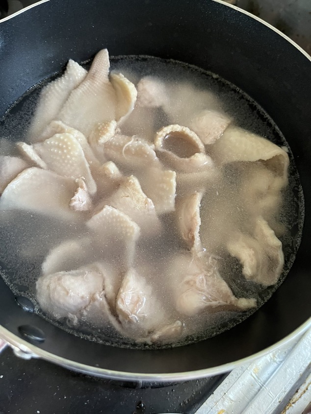 `Chicken skin near the end of parboiling in a pot of hot water