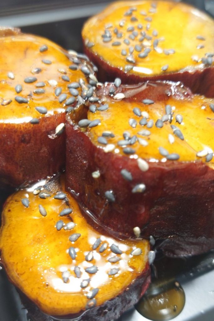 Daigaku Imo With Black Sesame Thick round slices of glazed daigaku imo sweet potato topped with black sesame seeds