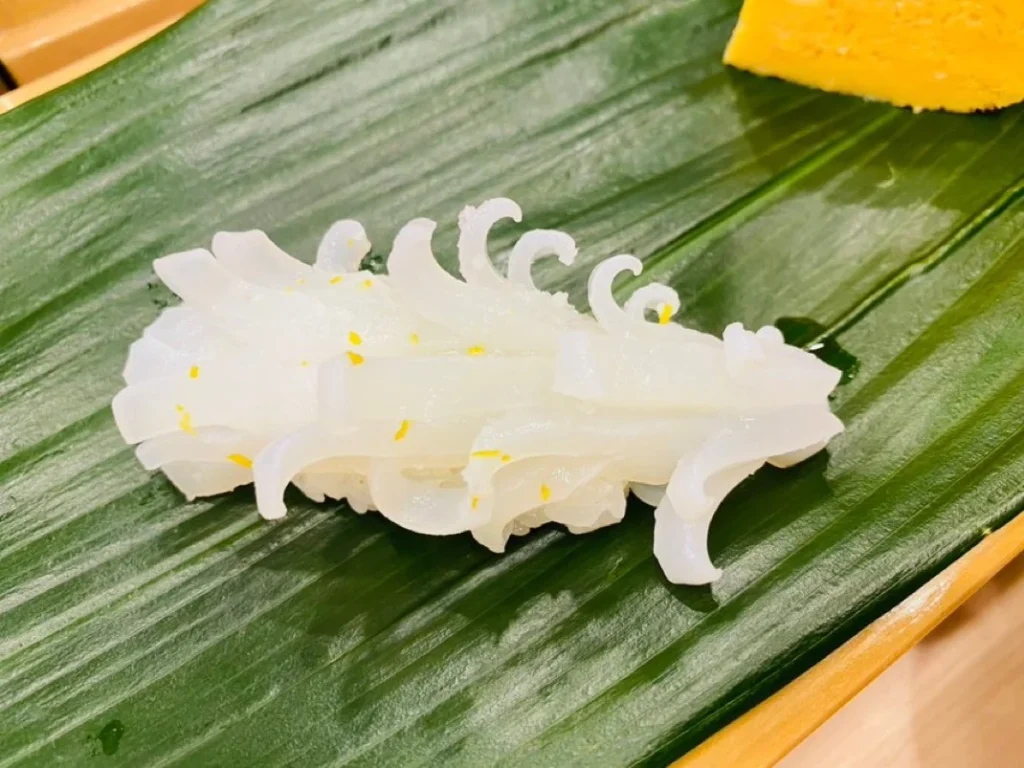 Decorative Squid Nigiri With Fine Cuts Decorative white squid nigiri with fine curled cuts and yellow citrus zest