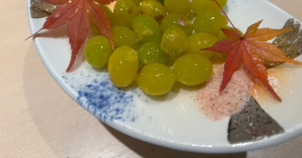 Glossy green ginkgo nuts served with salt and red maple leaves in Japan