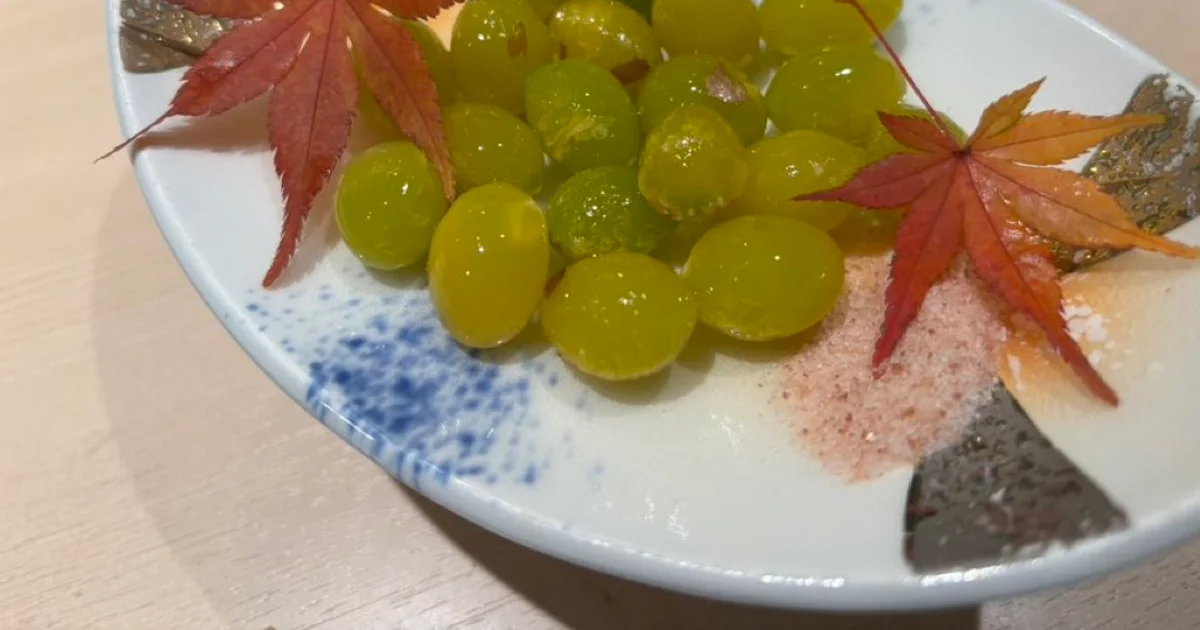 Glossy green ginkgo nuts served with salt and red maple leaves in Japan