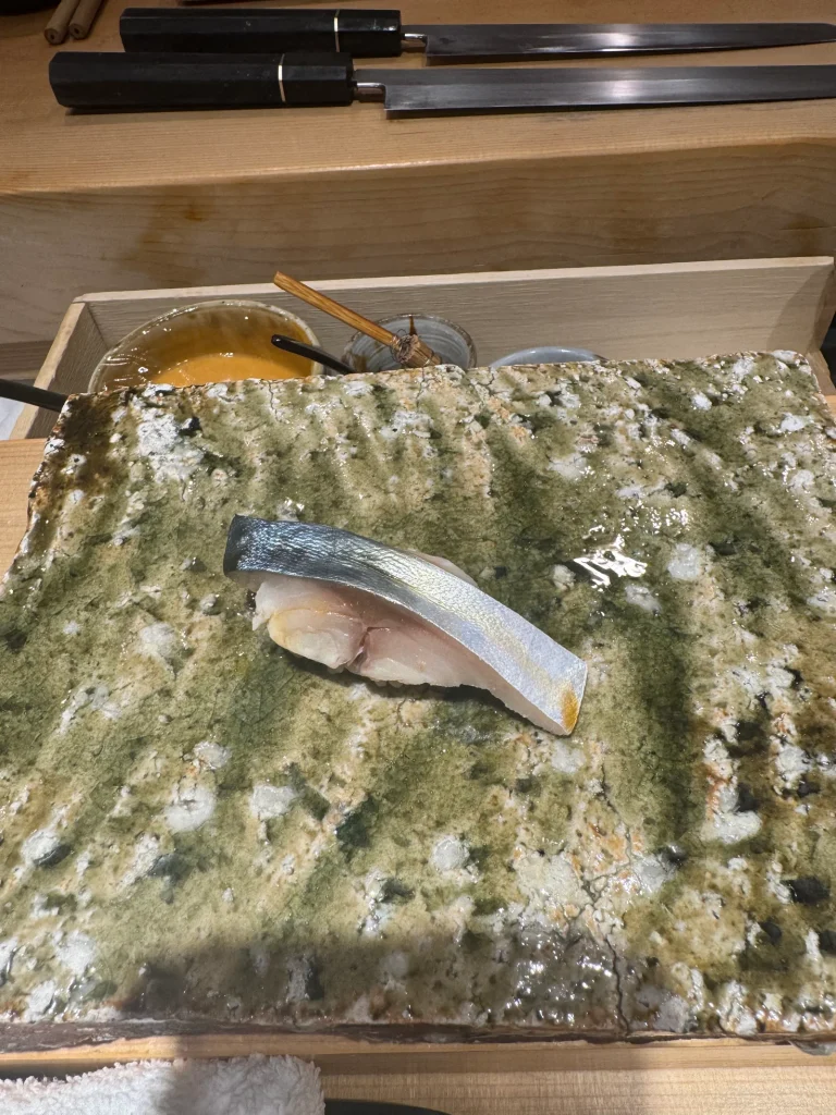 Silver-Skinned Fish Nigiri With Cooler Shari Silver-skinned fish nigiri served at a sushi counter where slightly cooler shari is used to balance its aroma