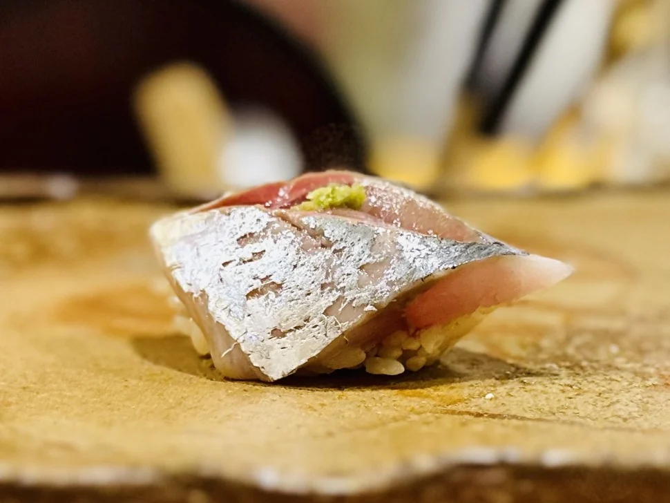 Silver-skinned fish nigiri topped with a small amount of wasabi