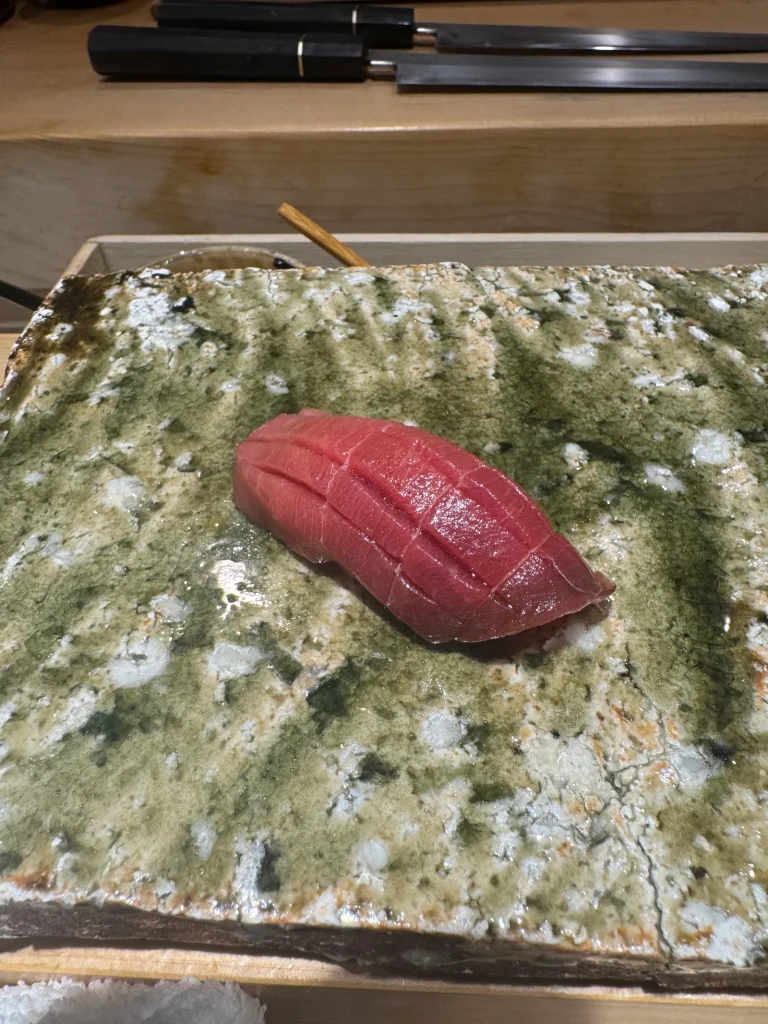 Tuna Nigiri With Warm Shari Tuna nigiri served at a sushi counter where warmer shari is used to bring the fish and rice together